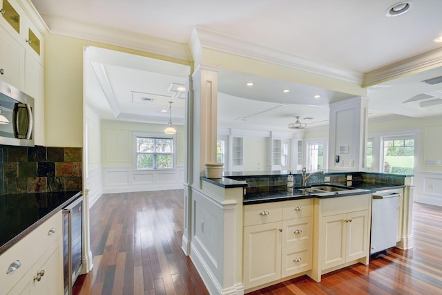 kitchen featuring kitchen peninsula, ornamental molding, stainless steel appliances, and wine cooler