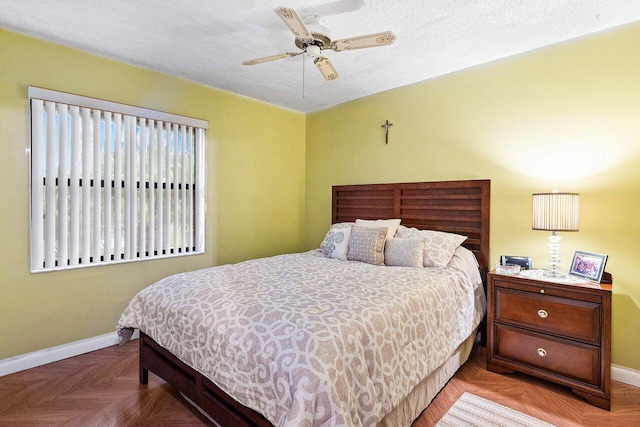 bedroom featuring parquet flooring, ceiling fan, and a textured ceiling