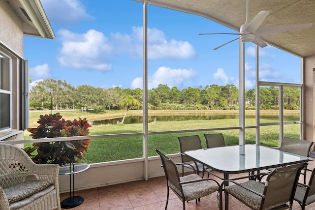 sunroom / solarium with a water view and ceiling fan