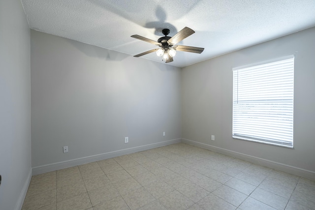 empty room featuring a textured ceiling, plenty of natural light, and ceiling fan