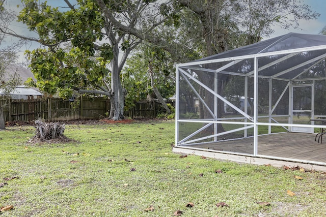 view of yard with a deck and glass enclosure