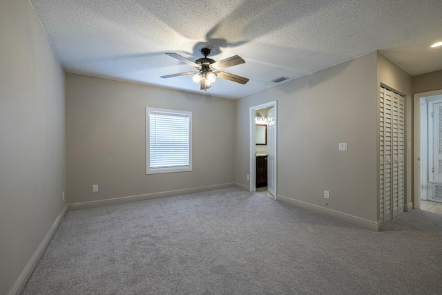 spare room with light carpet, a textured ceiling, and ceiling fan