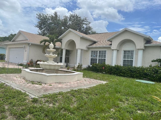 view of front of home featuring a garage and a front lawn