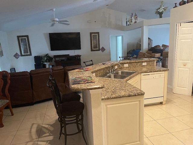 kitchen featuring white dishwasher, sink, white cabinets, light tile patterned flooring, and lofted ceiling