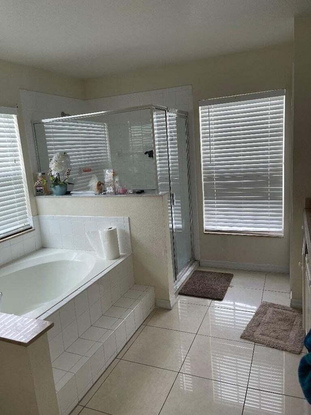 bathroom featuring shower with separate bathtub and tile patterned flooring