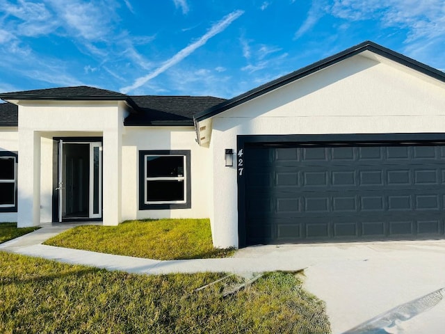 view of front of house featuring a garage and a front lawn