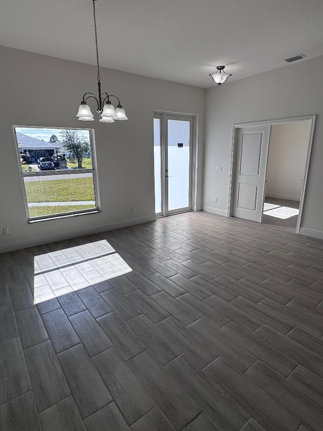 unfurnished room with a notable chandelier