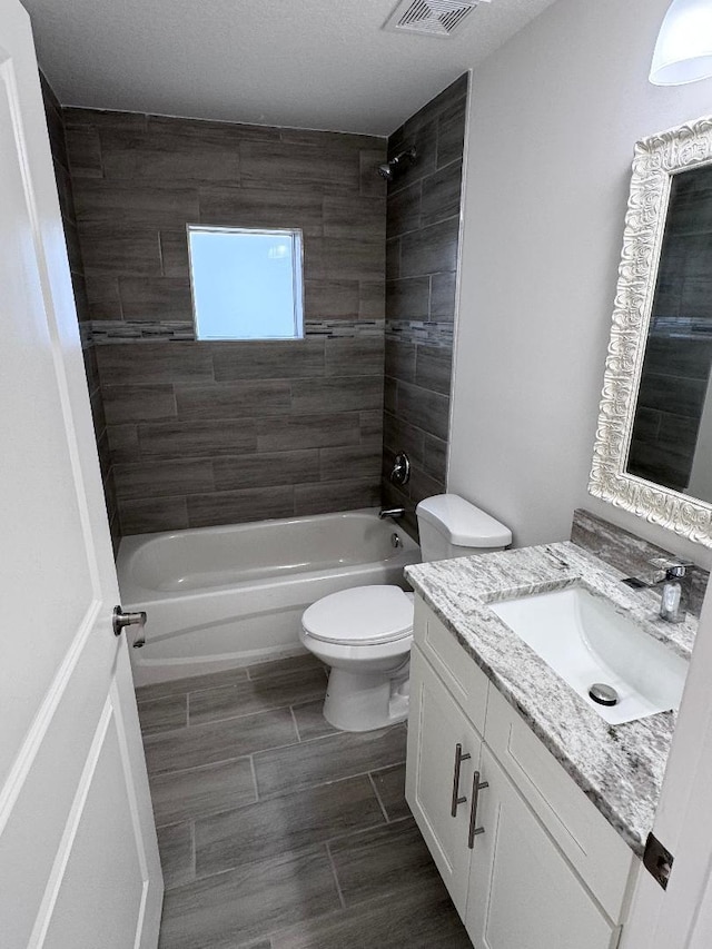 full bathroom with vanity, toilet, and tiled shower / bath combo