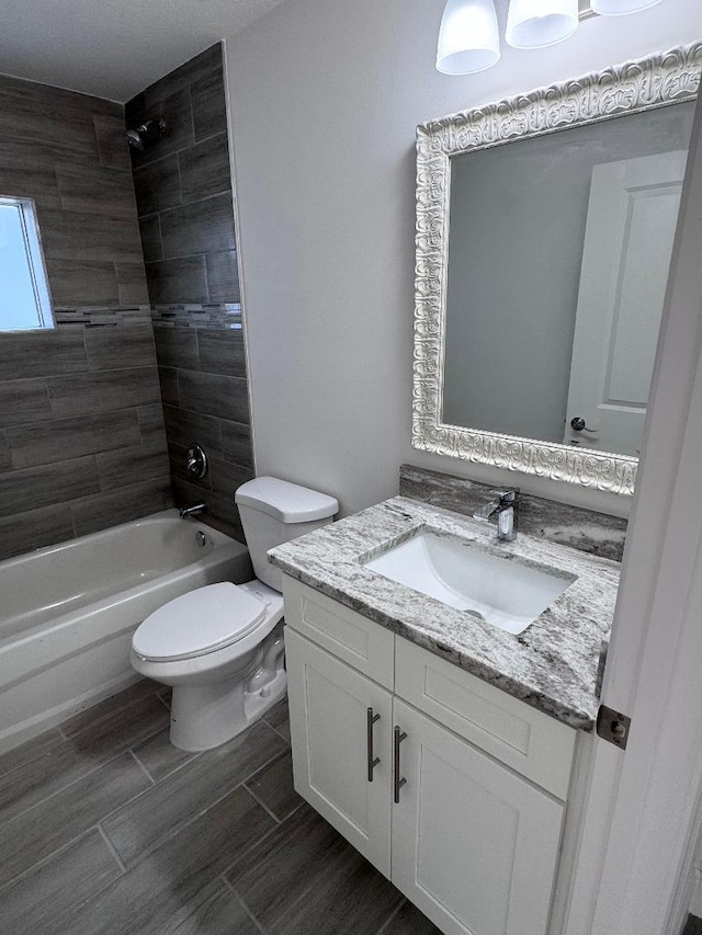 full bathroom featuring vanity, toilet, and tiled shower / bath combo