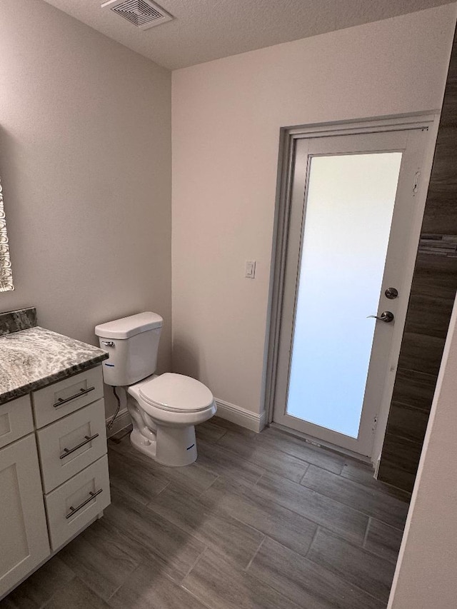 bathroom with vanity, hardwood / wood-style floors, and toilet