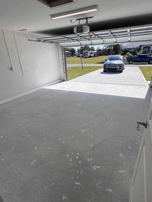 garage featuring a garage door opener and a lawn