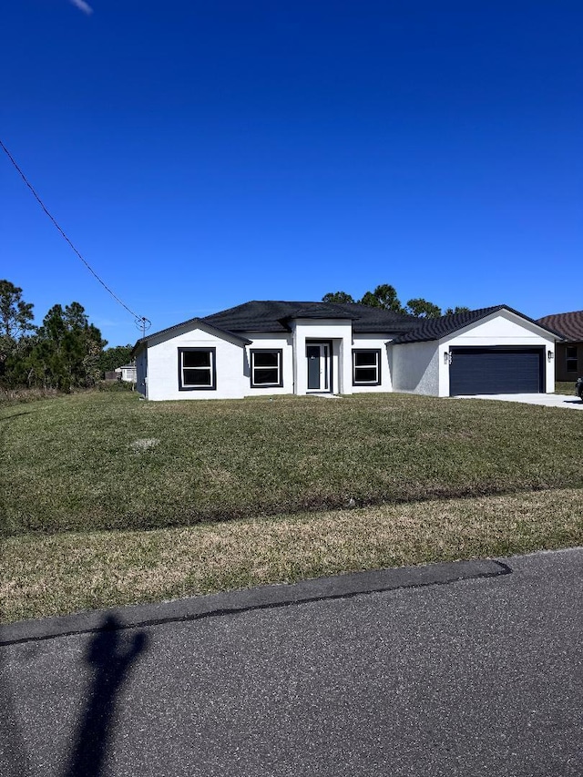 view of front of home with a garage and a front yard