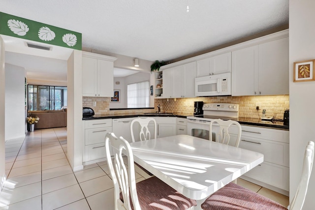 kitchen featuring white cabinetry, white appliances, sink, and light tile patterned floors