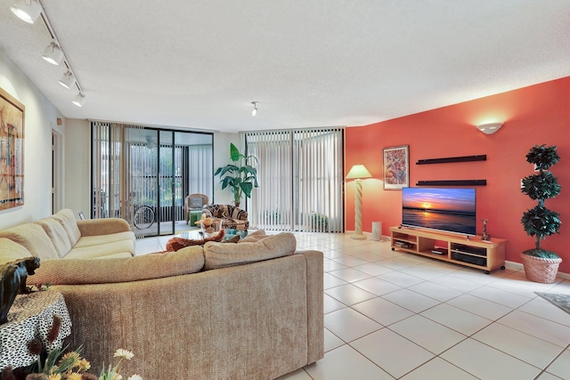 living room featuring track lighting, a wall of windows, a textured ceiling, and light tile patterned floors