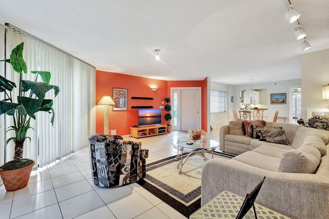 tiled living room with rail lighting and a textured ceiling