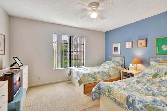 carpeted bedroom featuring ceiling fan and a textured ceiling