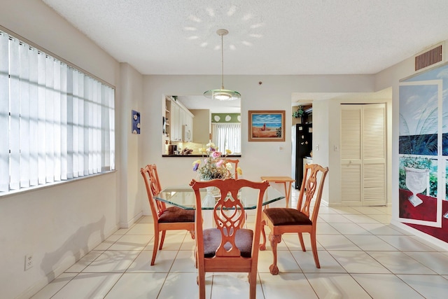 dining room with a textured ceiling and light tile patterned floors