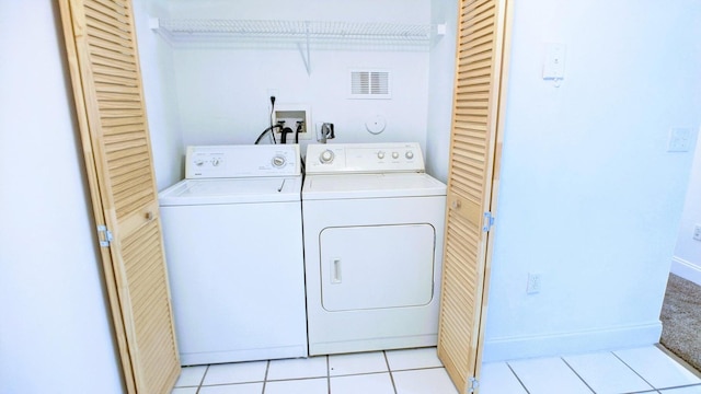 washroom with separate washer and dryer and light tile patterned floors