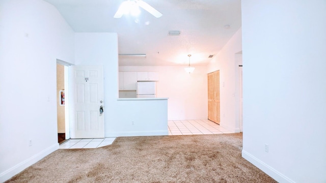 empty room with ceiling fan, light carpet, and vaulted ceiling