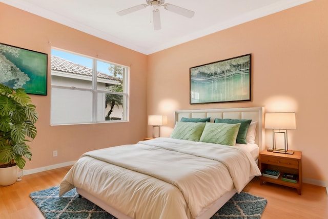 bedroom featuring ornamental molding, light hardwood / wood-style floors, and ceiling fan