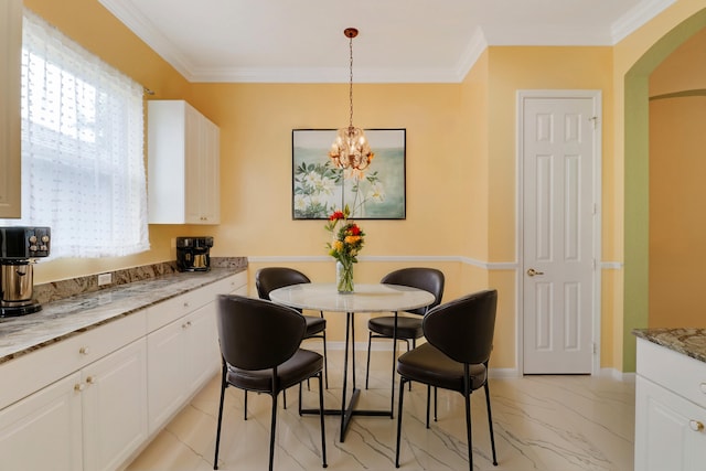 dining room with ornamental molding and a notable chandelier