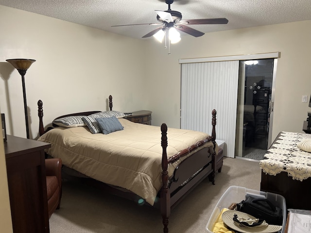 bedroom with ceiling fan, light carpet, and a textured ceiling