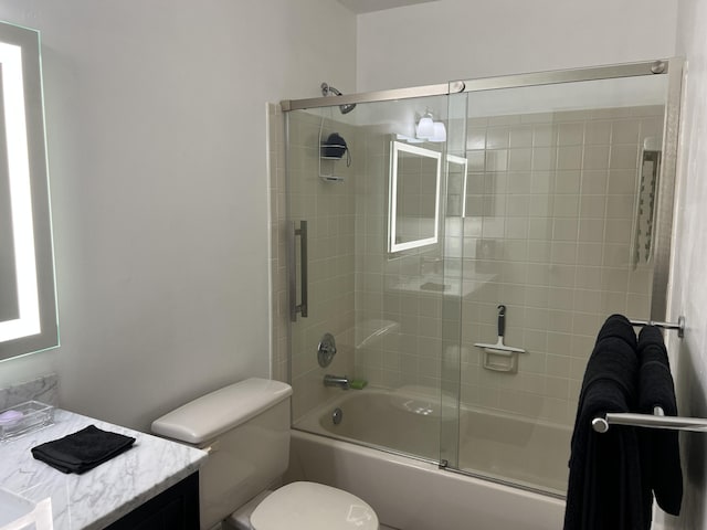 full bathroom featuring enclosed tub / shower combo, vanity, and toilet