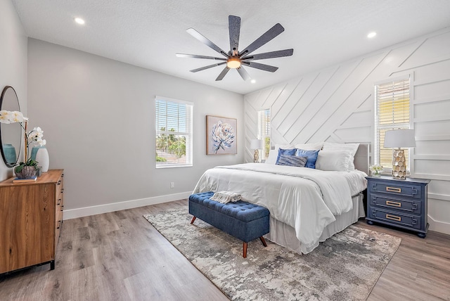 bedroom featuring ceiling fan, a textured ceiling, and light wood-type flooring