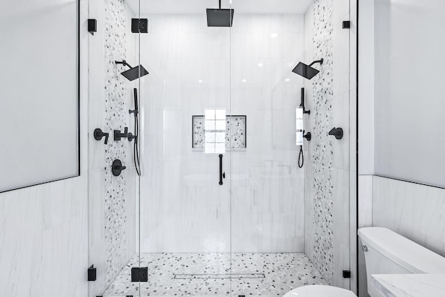 bathroom with tile walls, an enclosed shower, and toilet