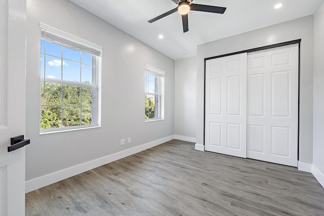 unfurnished bedroom with wood-type flooring, a closet, and ceiling fan