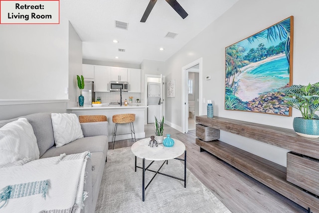 living room with ceiling fan and light wood-type flooring