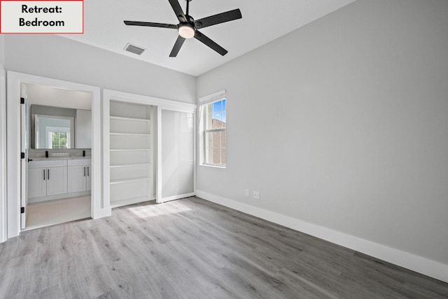 unfurnished bedroom featuring ceiling fan, ensuite bath, and light wood-type flooring