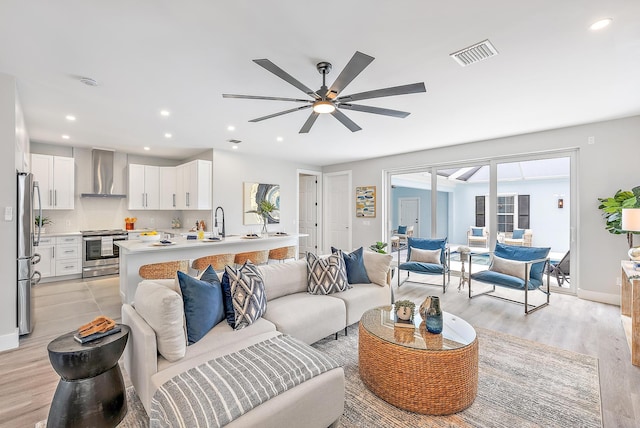 living room featuring ceiling fan and light wood-type flooring