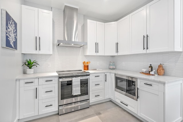 kitchen featuring black microwave, white cabinetry, backsplash, wall chimney exhaust hood, and stainless steel electric range