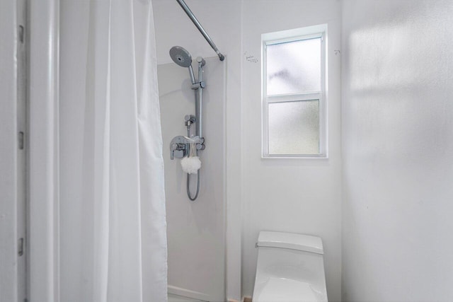 full bathroom with a shower with shower curtain and toilet