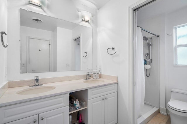 full bathroom with toilet, a stall shower, a sink, and visible vents