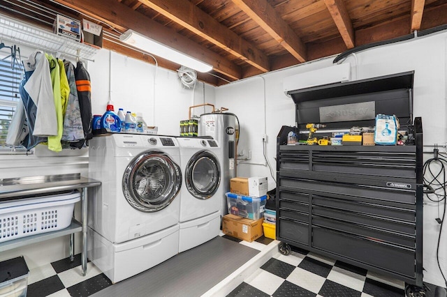 washroom featuring water heater, laundry area, washing machine and clothes dryer, and tile patterned floors