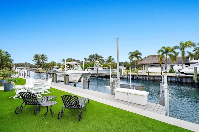 view of dock featuring a water view, a lawn, and boat lift