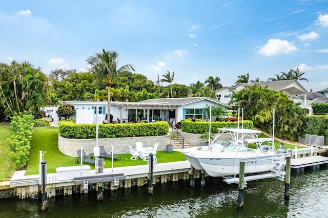 dock area featuring a water view, a lawn, and boat lift