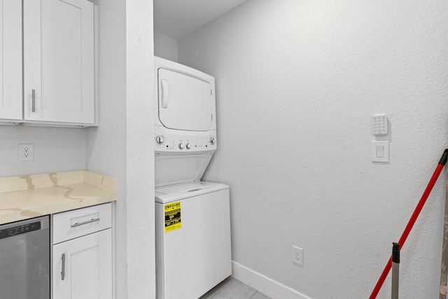 laundry area featuring stacked washing maching and dryer and light tile patterned floors