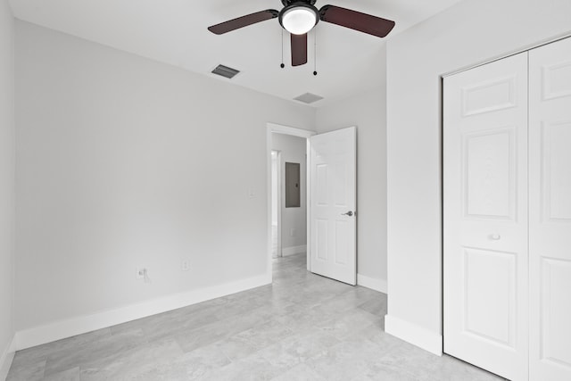 unfurnished bedroom featuring electric panel, ceiling fan, and a closet