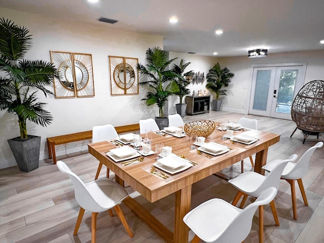 dining space with light hardwood / wood-style flooring and french doors