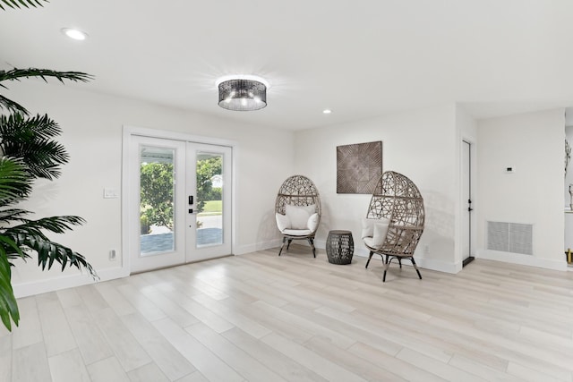 sitting room featuring french doors and light wood-type flooring