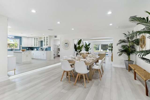 dining space with sink and light hardwood / wood-style floors