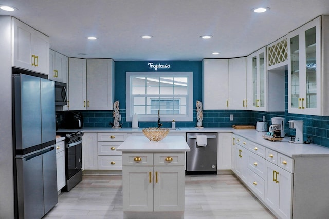 kitchen featuring white cabinets, stainless steel appliances, tasteful backsplash, sink, and light hardwood / wood-style flooring