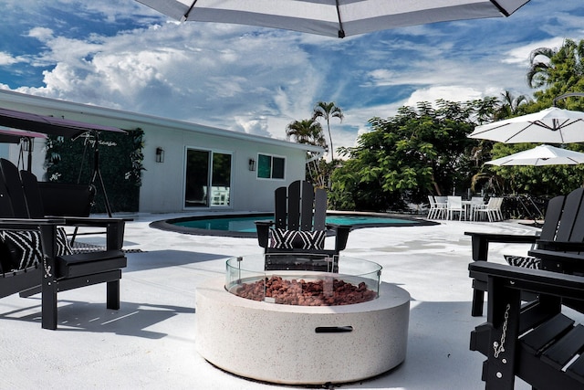 view of swimming pool featuring a fire pit and a patio