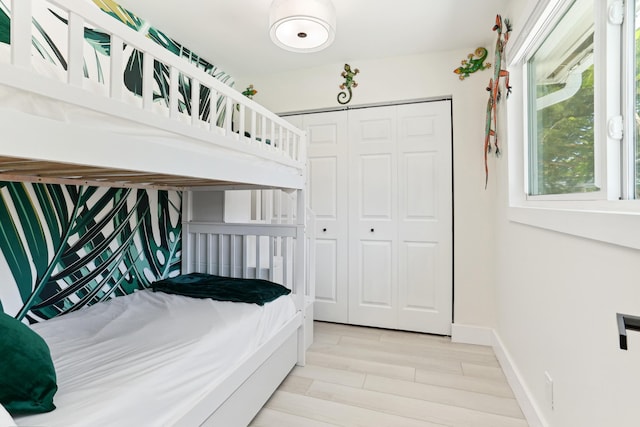 bedroom with light hardwood / wood-style floors and a closet