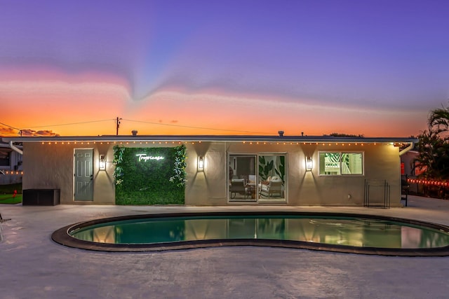 pool at dusk with a patio