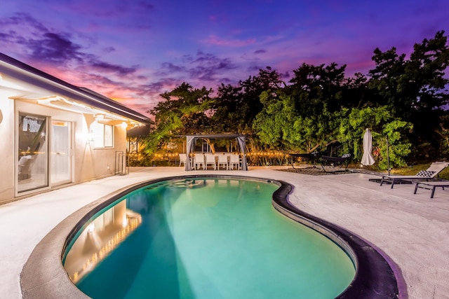 pool at dusk with a bar and a patio