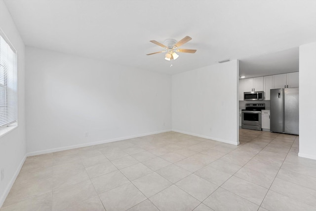 spare room featuring ceiling fan and light tile patterned flooring